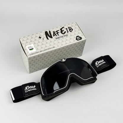 Black goggles with 'Deus Ex Machina' branding on a white background, next to a branded box.
