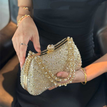 Gold beaded clutch held by a hand with a blurred background