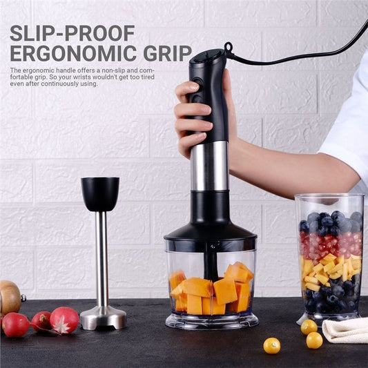 Hand blender with slip-proof ergonomic grip being used on a kitchen counter with fruits and a glass container.