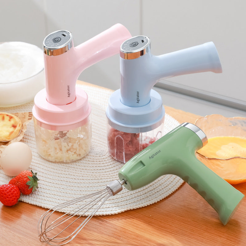 Electric whisk hand blender with wire whisk beaters and two clear mixing cups, pink and blue/green