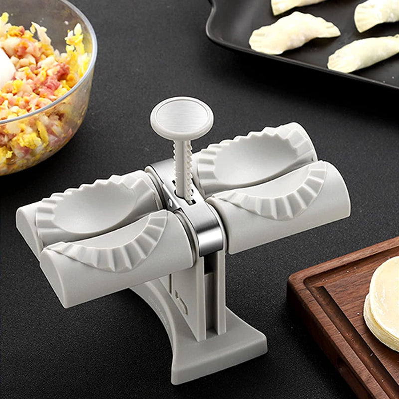 White dumpling maker on a dark surface with ingredients and a tray of dumplings in the background.