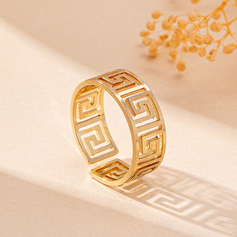 Gold-tone geometric Greek key ring, close-up of engraved design