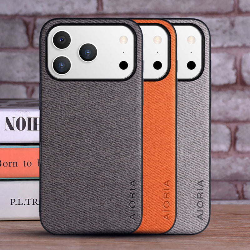 Two phone cases with gray and orange design on a wooden surface with books in the background.