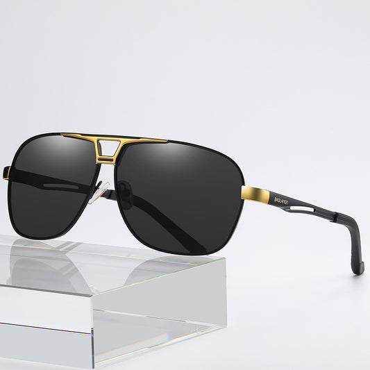 Sunglasses with gold frame and black lenses on a reflective surface