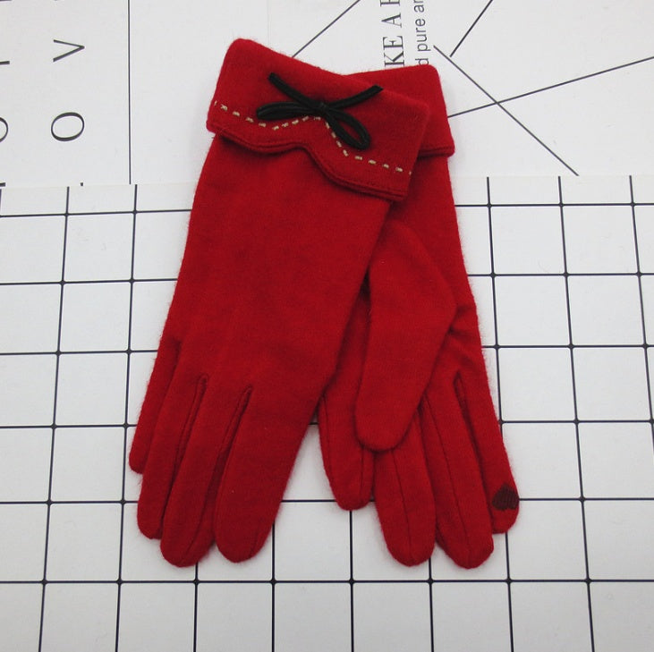 Red gloves with a bow on a grid background