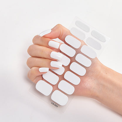 Hand holding a sheet of white nail extensions on a light gray background