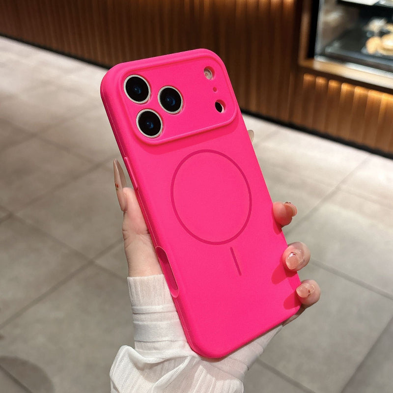 Pink phone case with a magnetic charging pad held by a hand on a tiled floor.