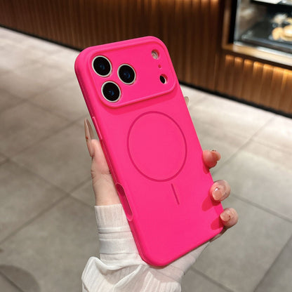 Pink phone case with a magnetic charging pad held by a hand on a tiled floor.