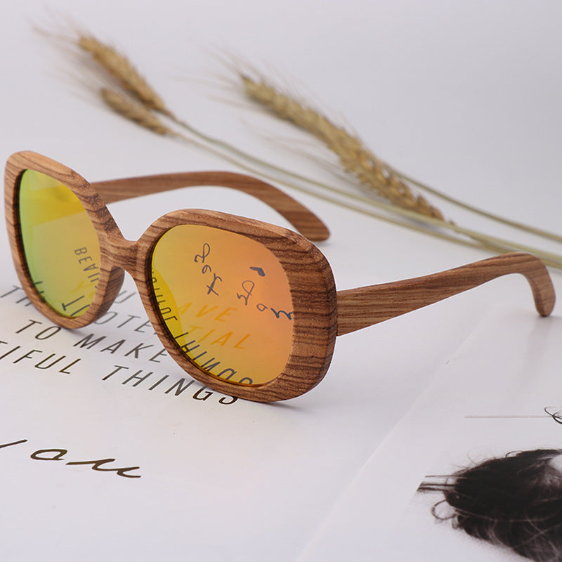 Brown wood-framed sunglasses with yellow tinted oval lenses and curved arms