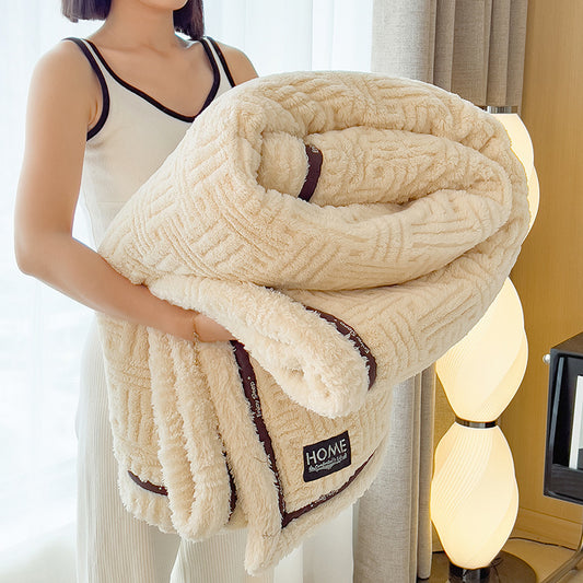 Person holding a textured beige blanket with 'HOME' branding.