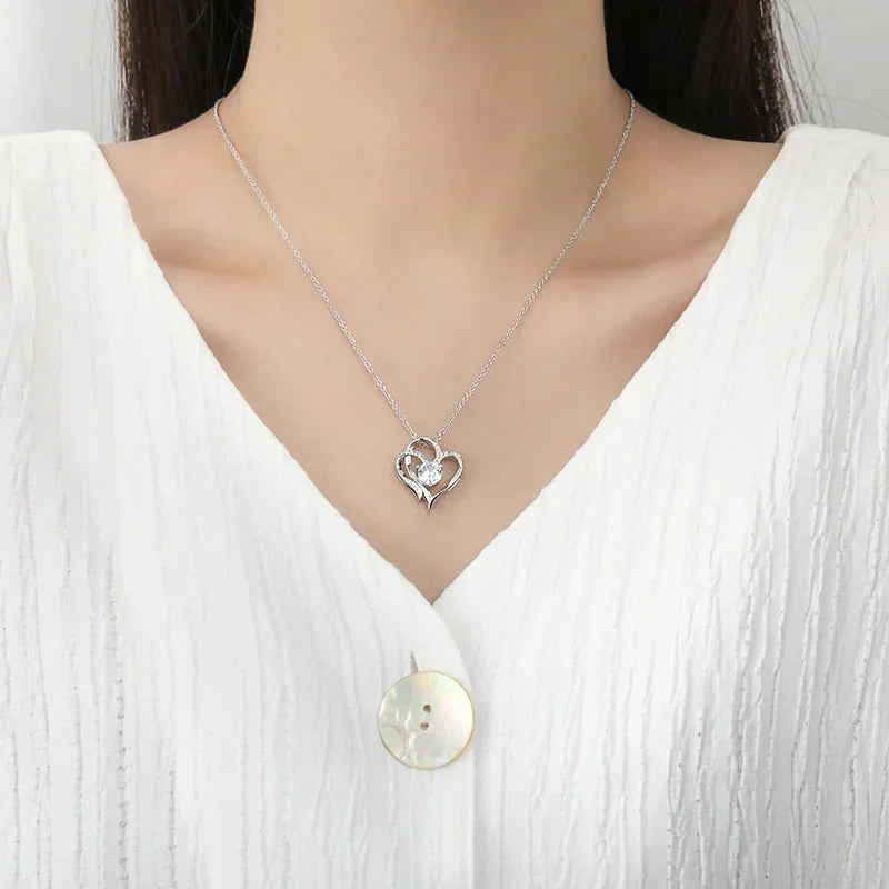 White gold heart pendant necklace with two stacked hearts and a central round stone