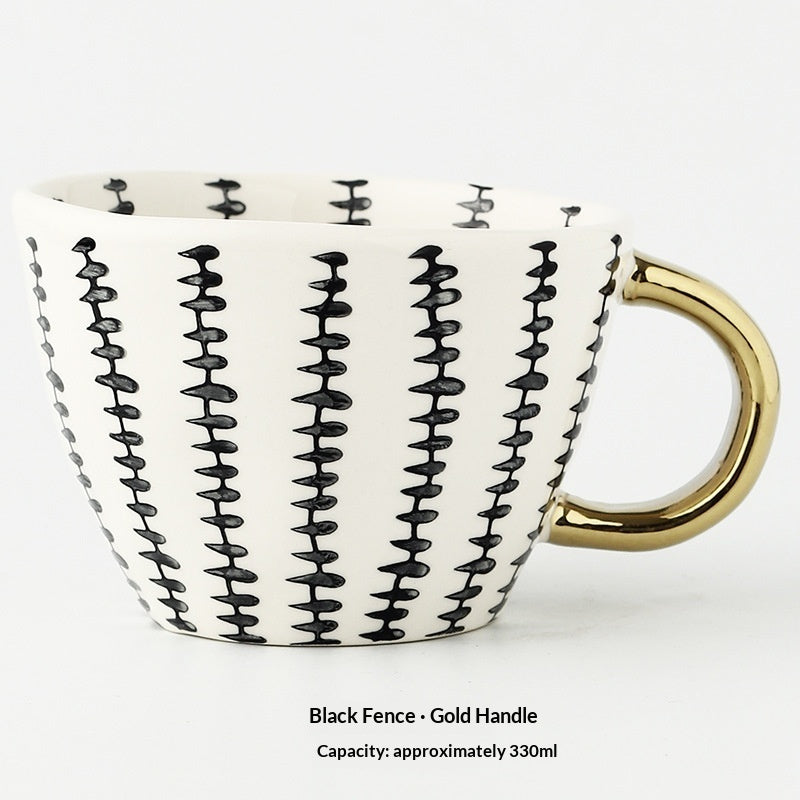 White ceramic mug with black fence-style pattern and gold handle