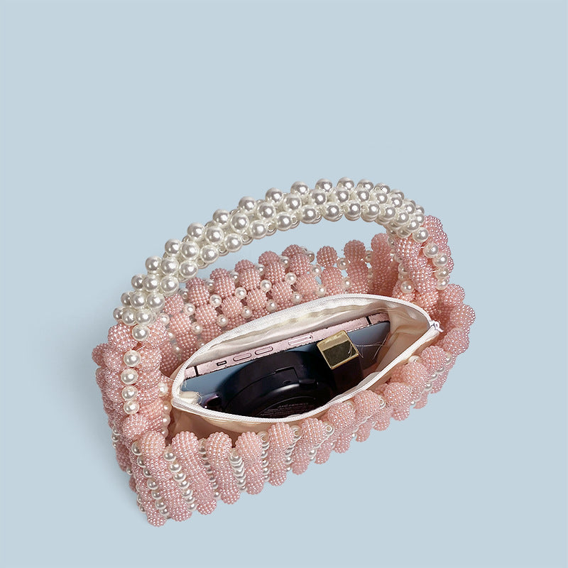 Pink pearl-beaded ball handbag with open top showing inner pocket and beaded lining