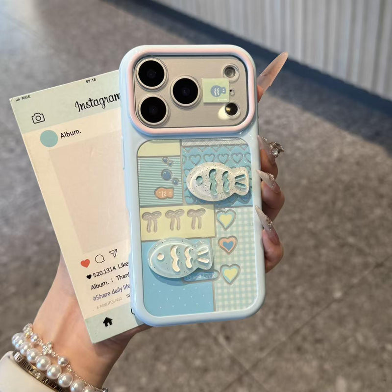 Pale blue iPhone case with hearts, checkered blocks, and raised 3D fish detail