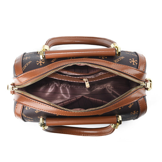 Brown and black handbag with gold accents on a white background