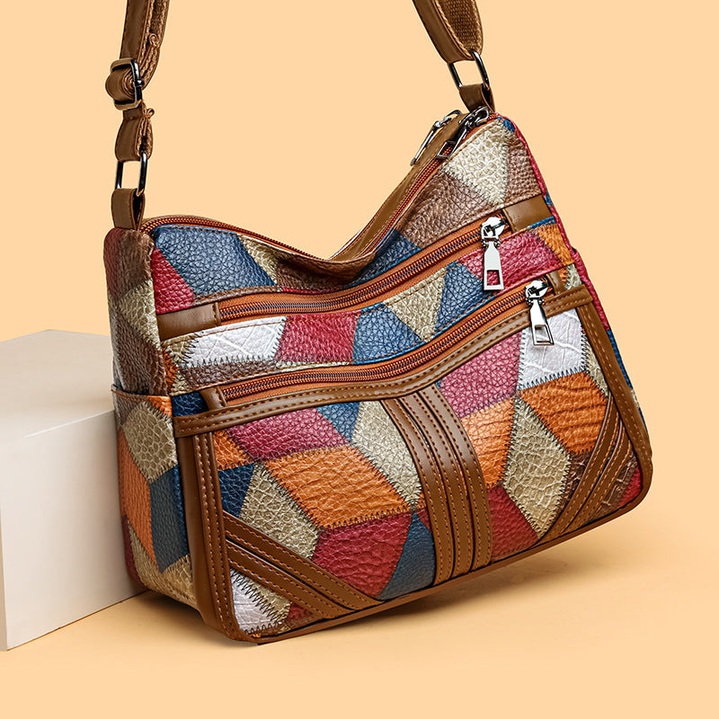 Women's patchwork crossbody bag with brown strap, multiple zip compartments and flap front