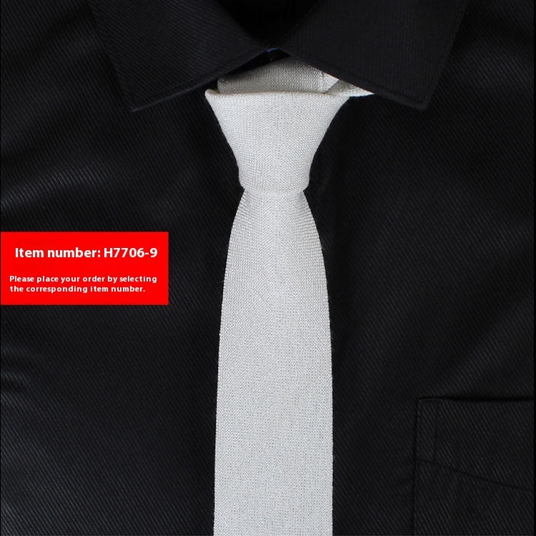 Narrow cotton tie in white textured fabric, slim knot.
