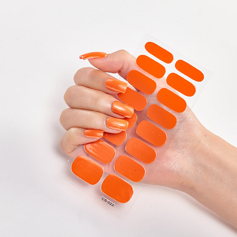 Hand with orange nail wraps on a white background