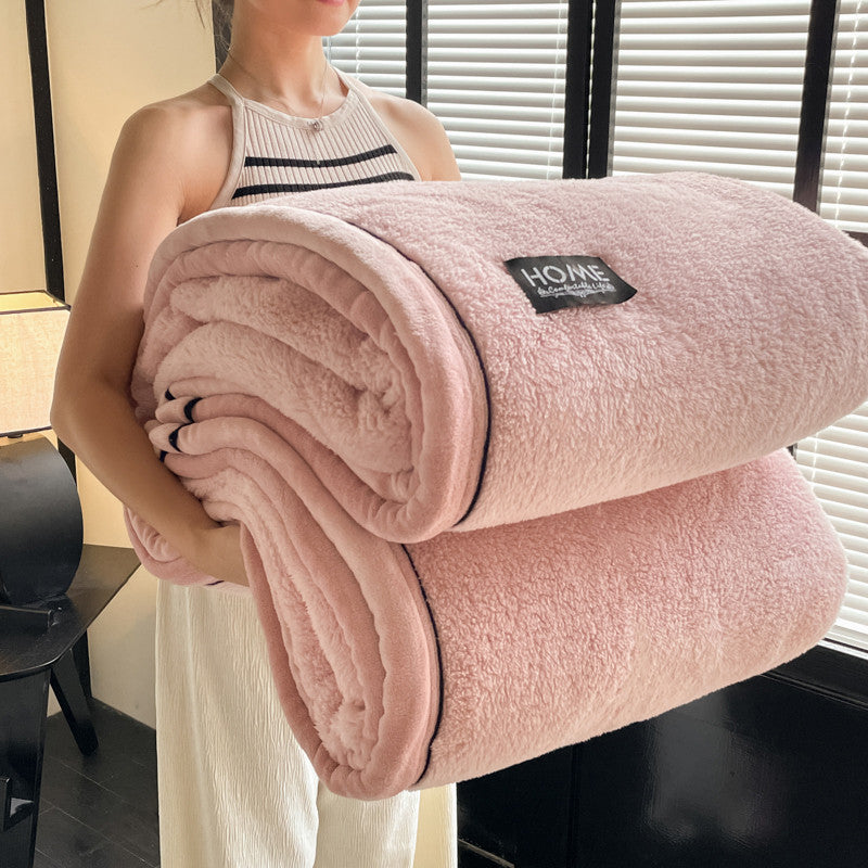 Velvet solid blush-pink blanket rolled, plush pile with HOME label and dark trim