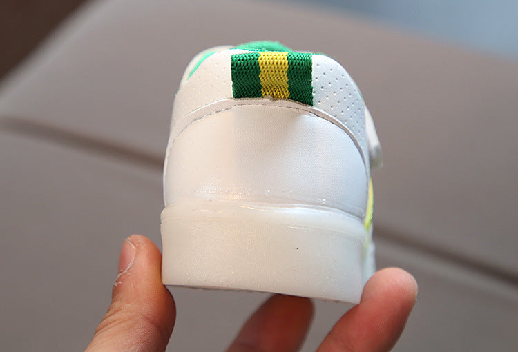 Kids white LED light-up sneaker heel with green collar lining; rounded toe view
