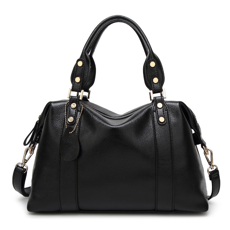 Black PU leather tote handbag with top handles, side tassel straps, and gold hardware