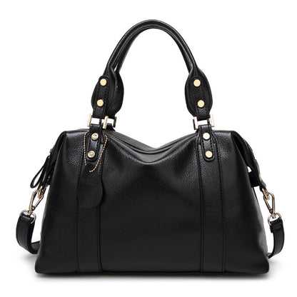 Black PU leather tote handbag with top handles, side tassel straps, and gold hardware