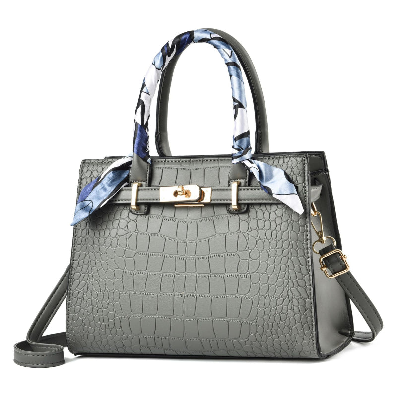 Gray croc-textured tote bag with blue patterned scarf handles and shoulder strap
