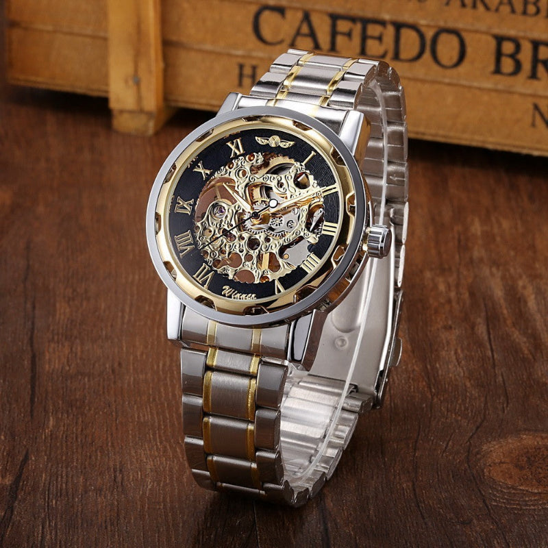Silver and gold watch with a detailed face on a wooden surface