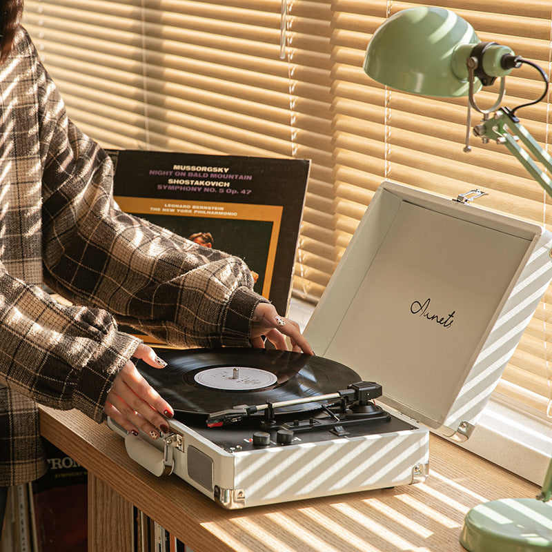 Portable Bluetooth record player phonograph in cream with record on turntable