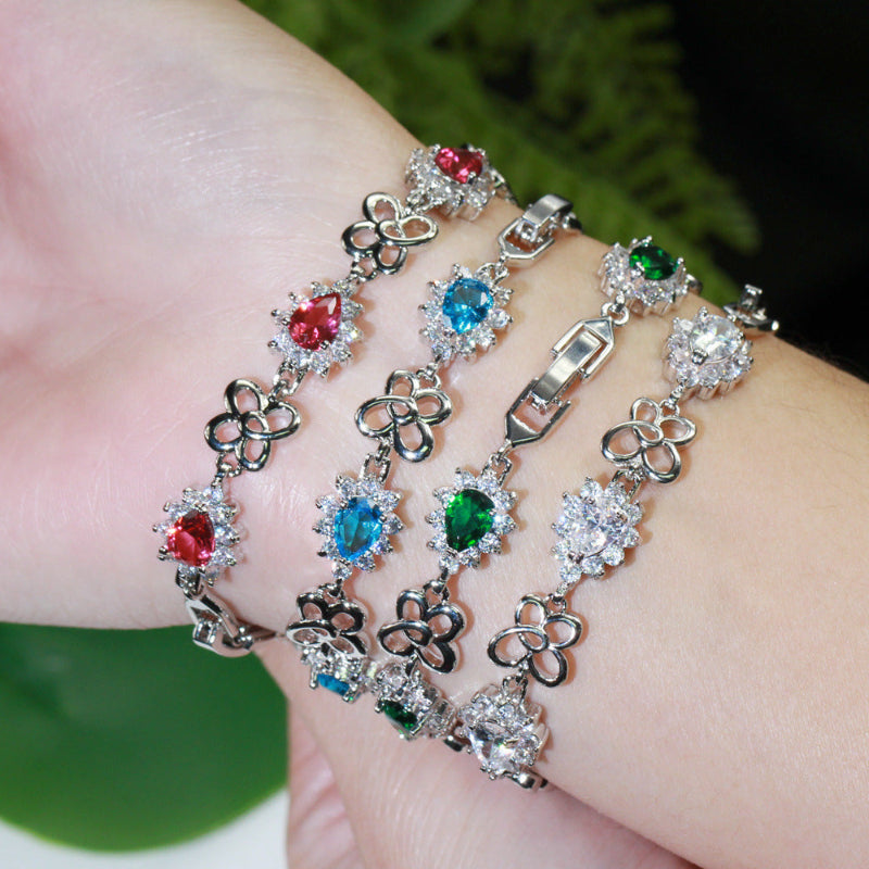 Gold-plated zircon bracelet on wrist with red, blue, and green gemstone links
