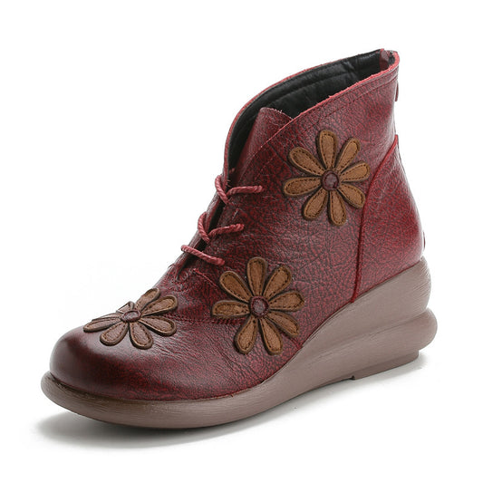 Red ankle boot with brown flower appliqués on a white background