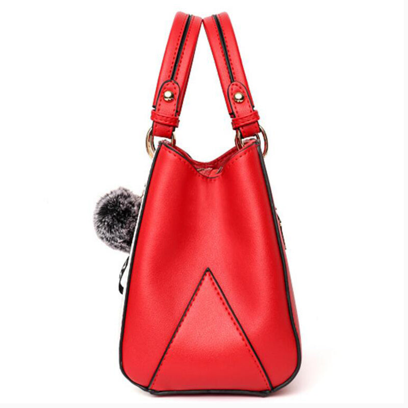 Red PU leather bucket-style handbag with two top handles and pompom charm