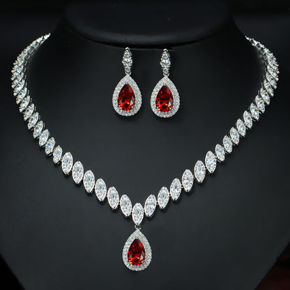 Jewelry set with necklace and earrings featuring red gemstones on a black background