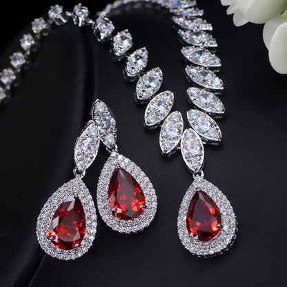 Jewelry set with red teardrop earrings and necklace on a black background