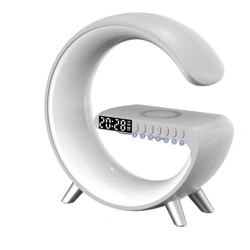 White G-shaped LED lamp with digital clock, speaker controls and wireless phone charging pad