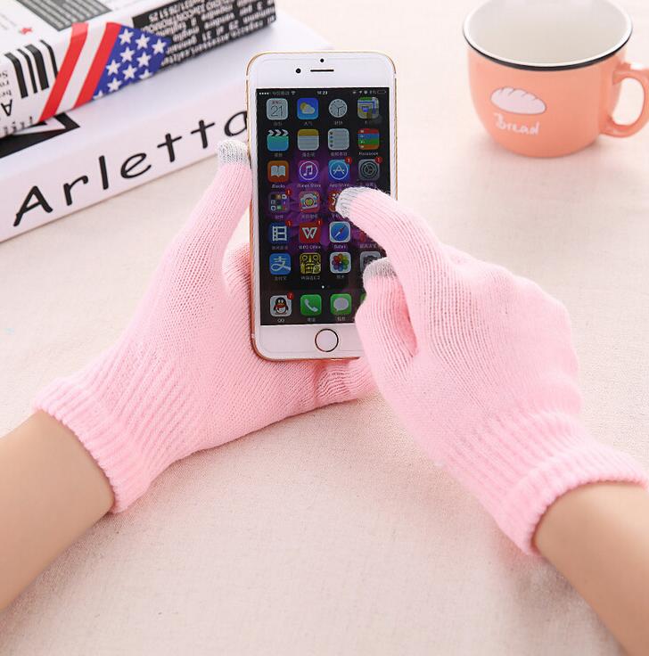 Light pink touchscreen knit gloves with ribbed cuffs, hands holding smartphone