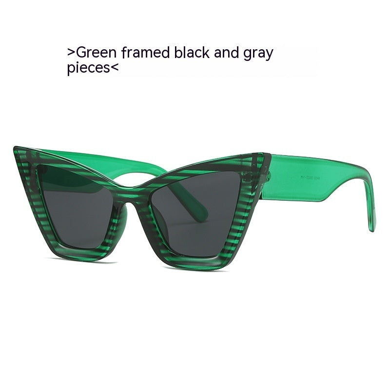 Green framed cat-eye sunglasses with dark black and gray tinted lenses