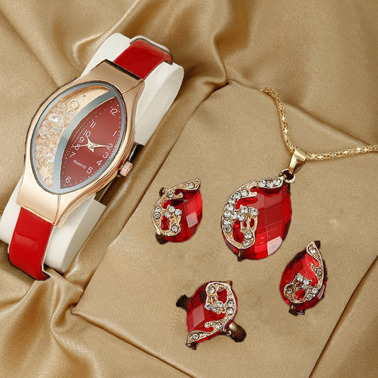 Jewelry set with a watch, necklace, and earrings on a beige fabric background
