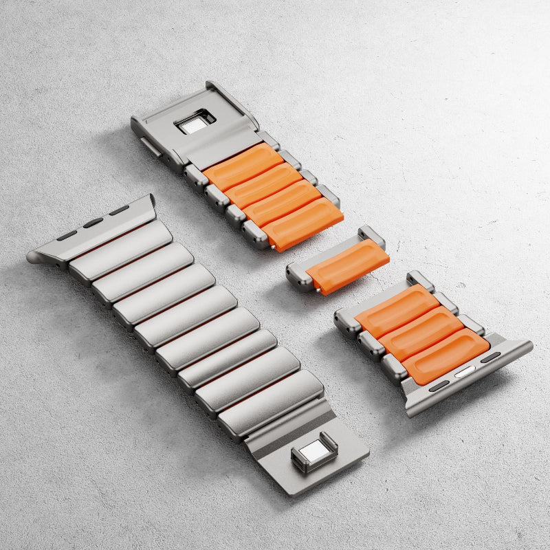 Metallic watch strap with orange accents on a gray surface