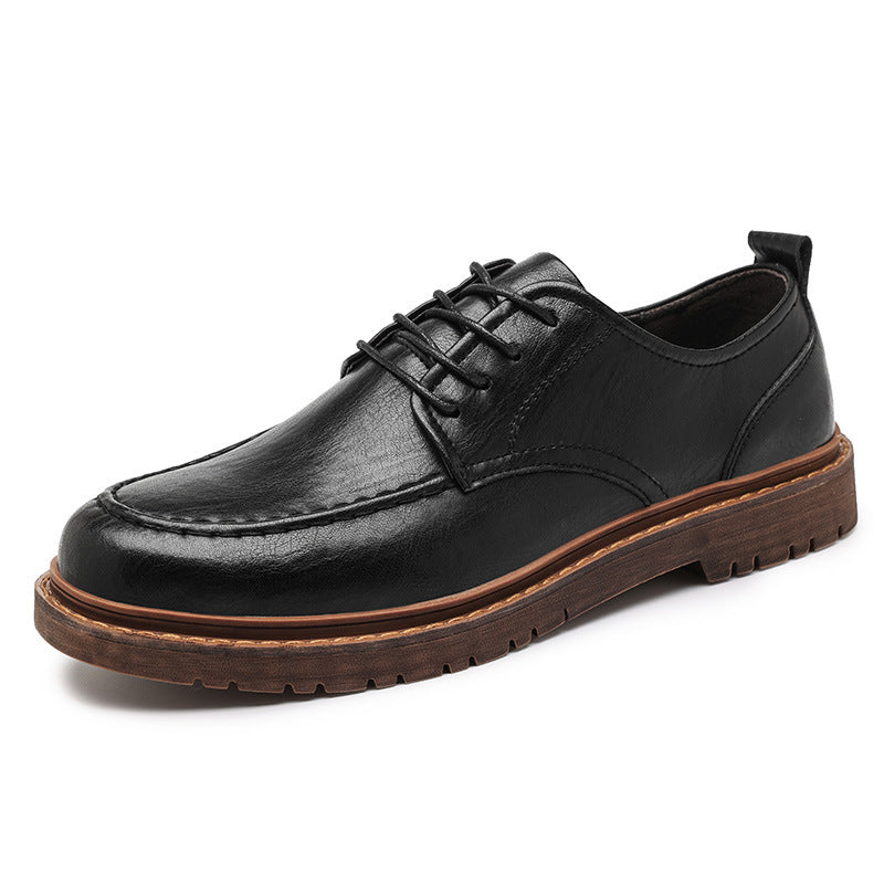 Black leather shoe with brown sole on a white background