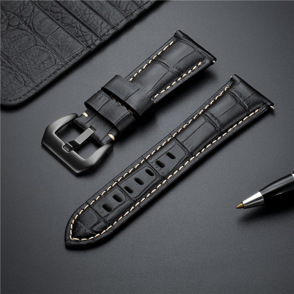 Dark leather watch strap set with two buckles and yellow edge stitching.