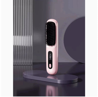 Pink hair straightening brush with digital display on a dark surface