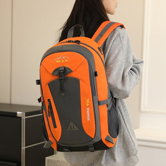 Person wearing an orange and gray backpack indoors