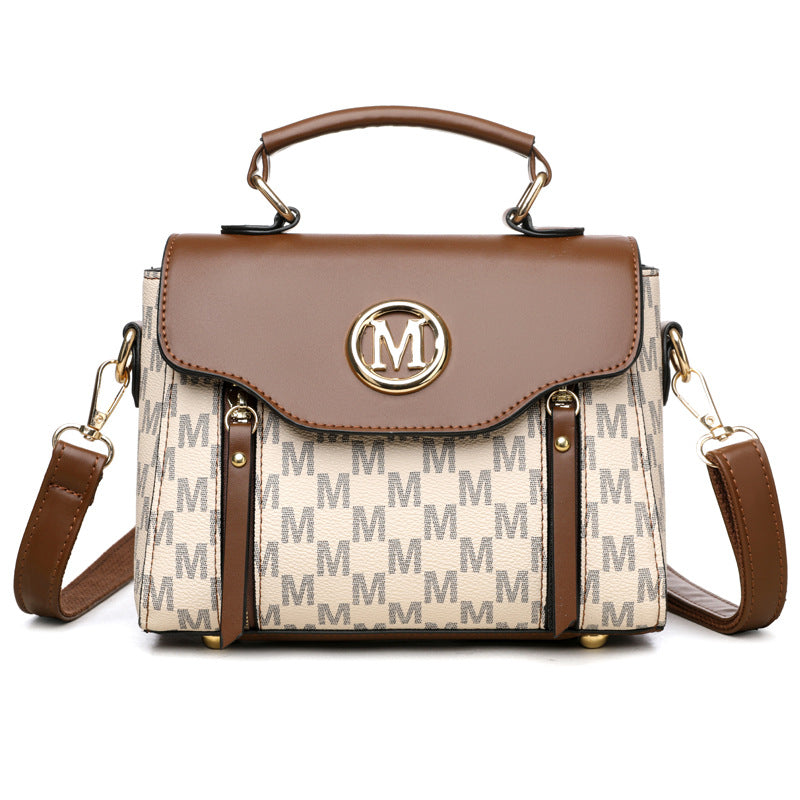 Light beige monogram crossbody handbag with flap top, gold M emblem, leather shoulder strap