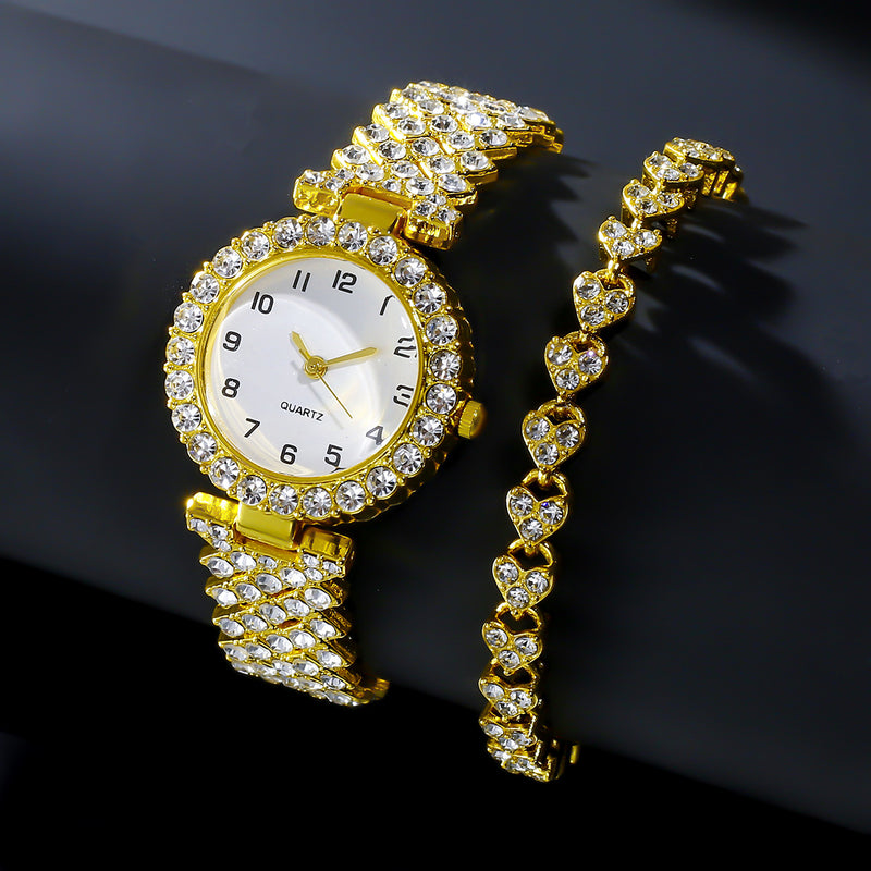 Gold-tone watch and matching stone-set heart-link bracelet on a dark background