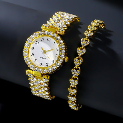 Gold-tone watch and matching stone-set heart-link bracelet on a dark background