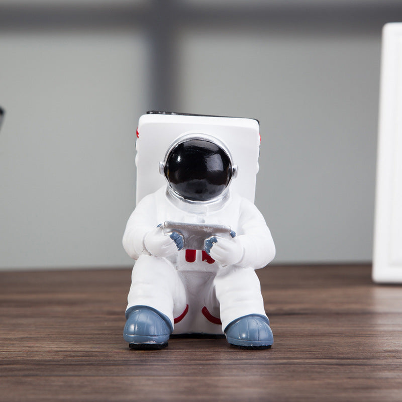 Astronaut mobile phone stand front view, black visor helmet and white suit