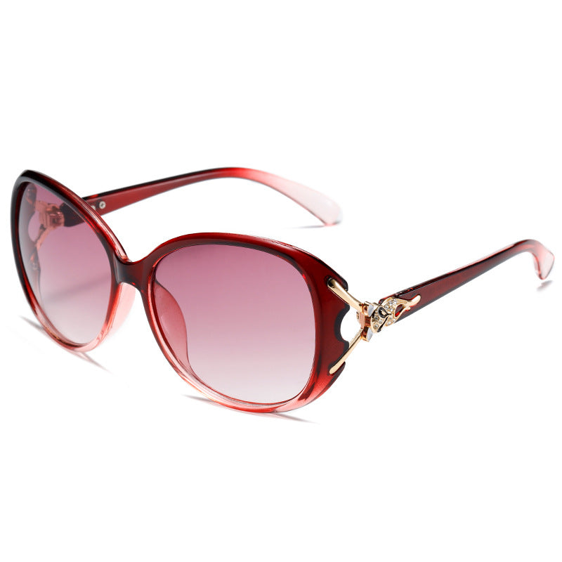Red sunglasses with a gold accent on a white background
