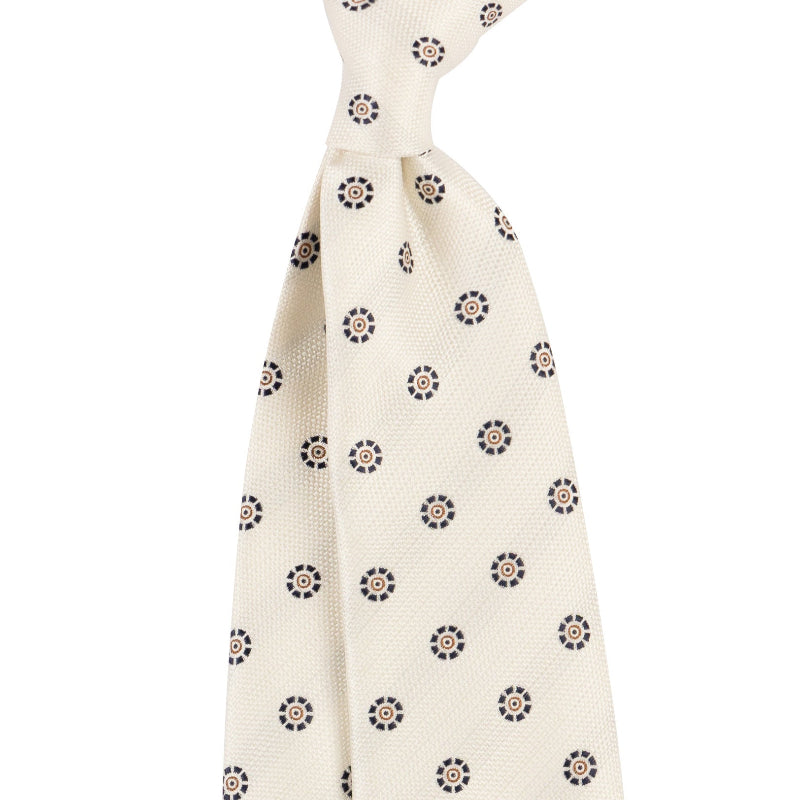 Cream white necktie with navy circular medallion repeat