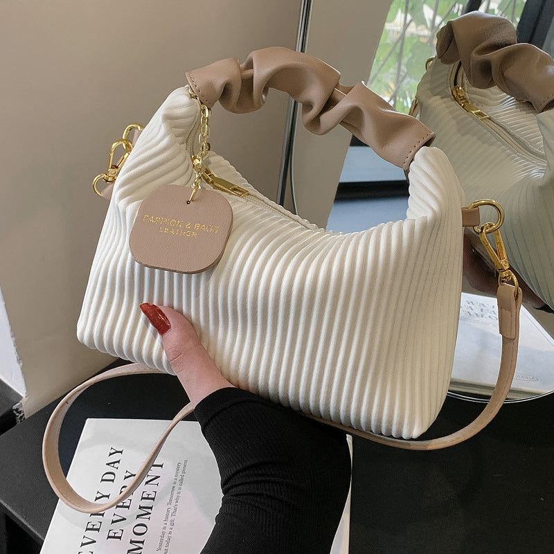 Cream ribbed PU leather crossbody bag with gold chain strap and round charm tag